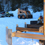 A group of people on snow vehicles in the snow.