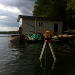 A boat is in the water with a house on it.