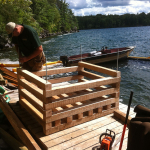 A man standing on top of a dock next to water.