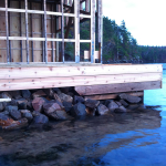 A dock with rocks and water in the background.