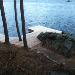 A dock with rocks and trees in the background