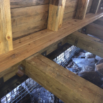 A wooden structure with some rocks in the background