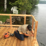 A man sitting on the edge of a dock.