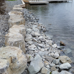 A boat is docked at the shore of a lake.