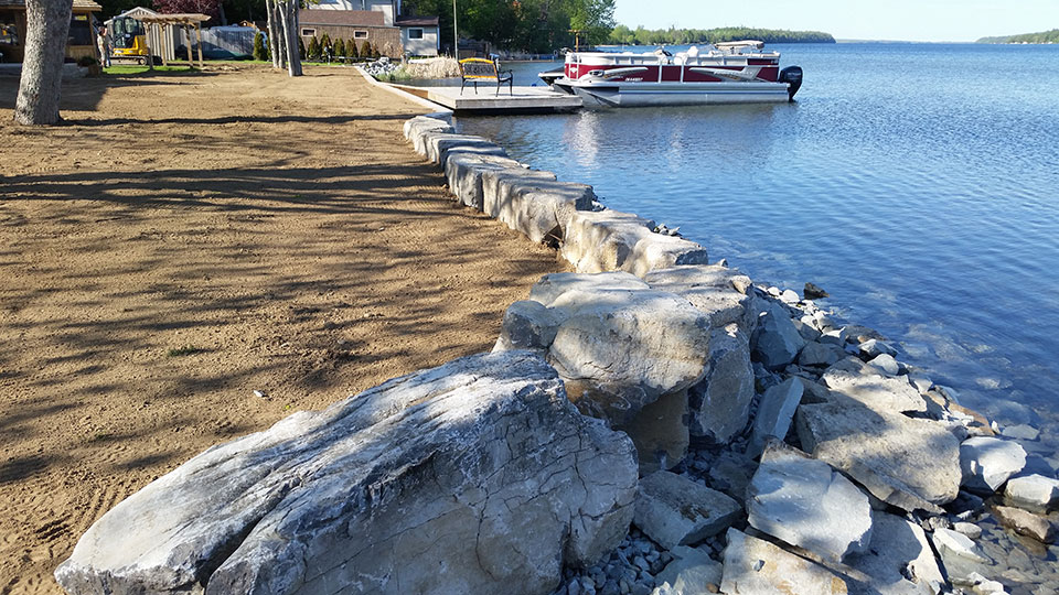 A boat is docked at the shore of a lake.